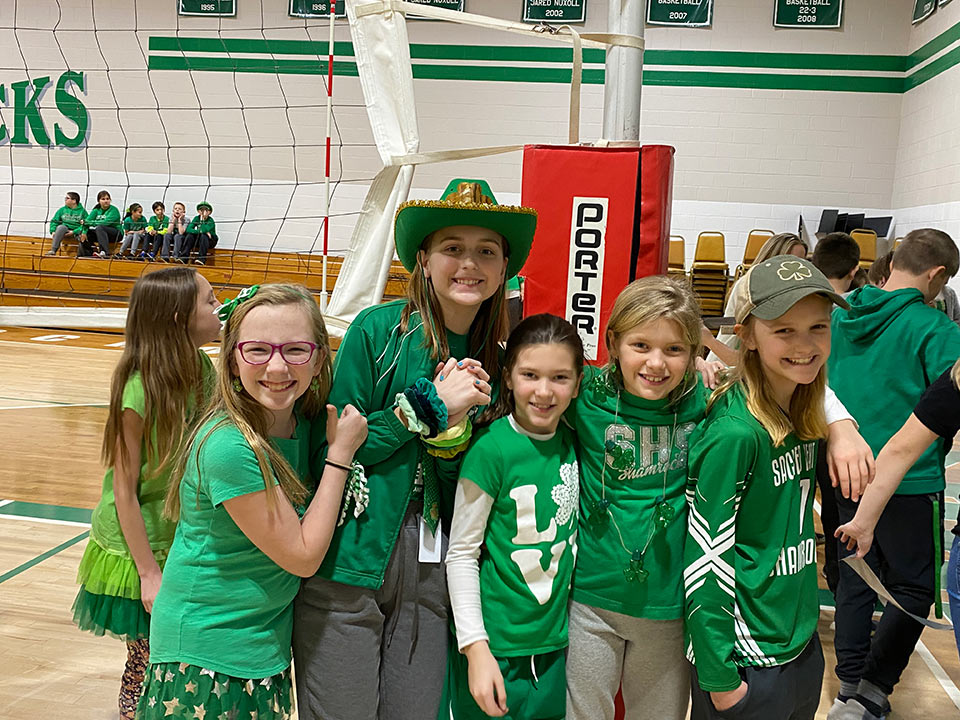 students standing together in their green and white attire